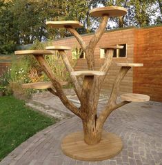 a wooden table that is sitting in the middle of a brick walkway next to a building