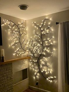 a living room with lights on the wall and a fire place in front of it