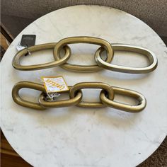 a white table topped with a metal chain on top of a marble slabd floor