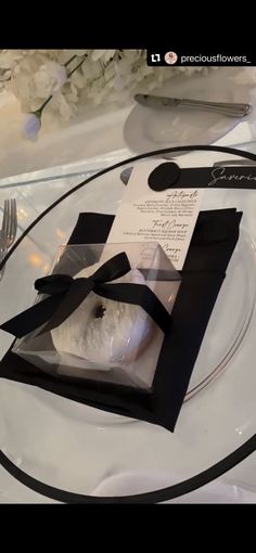 a table setting with black and white place settings, silverware and napkins on it