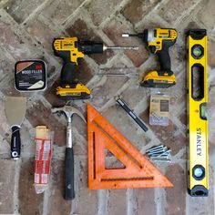 tools are laid out on the floor to be used for construction work, including screwdrivers and hammers