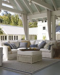 a living room filled with white furniture and lots of pillows on top of it's couches