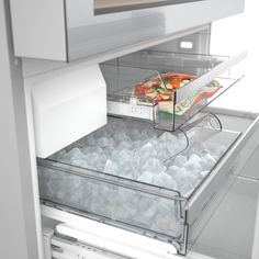 an open refrigerator door with ice and food in the freezer drawer, showing it's contents