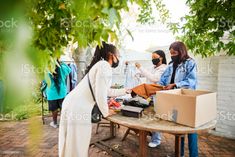 people standing around a table with boxes on it