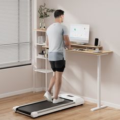 a man is standing on a treadmill and using the computer to monitor his body