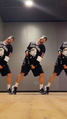 a man in black shirt and shorts dancing on wooden floor