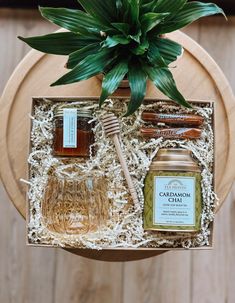 a wooden box with honey, candles and a plant