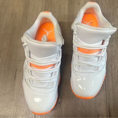 a pair of white shoes with orange soles