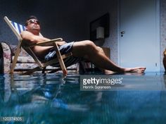 a man sitting in a chair next to a pool