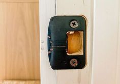 an old fashioned door handle on a white wooden door with a black and brown latch