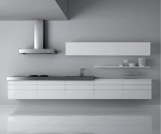 a modern kitchen with white cabinets and stainless steel counter tops is pictured in this black and white photo