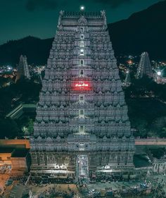 an aerial view of a very tall structure with lights on it's sides at night