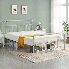 a metal bed frame with two drawers underneath it and a yellow blanket on the bottom