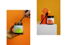 a hand holding a spoon over a jar of orange jam and an orange slice on top of the jar