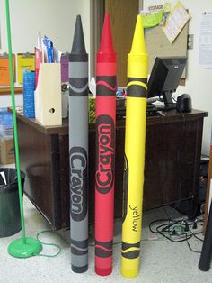 several crayons are lined up on the floor in front of a computer desk