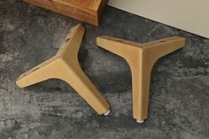 two wooden stools sitting on top of a cement floor