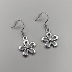 Add a touch of elegance to your outfit with these charming Tibetan Silver Daisy Earrings. The delicate flower shape and hook closure make them perfect for any occasion, whether it's Mother's Day, a wedding, an anniversary, Valentine's Day, or a birthday. These dangle/drop earrings are crafted with nickel-free materials and are handmade in the United Kingdom. These earrings are not only stylish but also personalizable. You can add text to the backing card, like "Daisy The Birth Flower Of April," Silver Flower Earrings For Mother's Day, Pierced Flower Earrings For Party, Party Flower-shaped Pierced Earrings, Elegant Hypoallergenic Metal Flower Earrings, Hypoallergenic Flower-shaped Earrings For Anniversary, Dainty Flower Charm Earrings For Mother's Day, Nickel Free Flower Shaped Earrings For Mother's Day, Flower-shaped Nickel-free Earrings For Mother's Day, Nickel-free Flower-shaped Earrings For Mother's Day