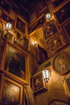 an ornately decorated room with paintings on the wall and lights hanging from the ceiling