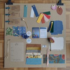 a bulletin board covered in lots of papers and magnets on top of a wooden floor