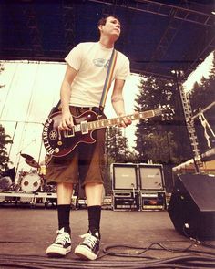 a man standing on top of a stage with a guitar in front of his face