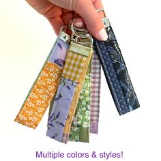 a person holding several different colored keychains with the words multiple colors & styles