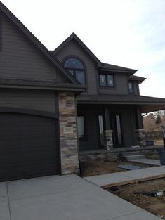 a house that is in the process of being remodeled with new siding and stone accents