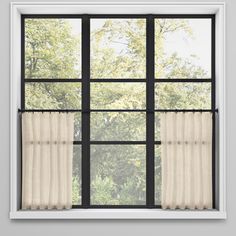 an open window with curtains and trees in the background