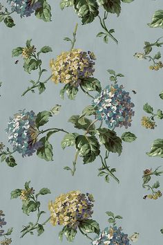 a blue and yellow flowered wallpaper with green leaves on the bottom half of it