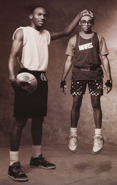 two black men standing next to each other holding a basketball in one hand and wearing shorts