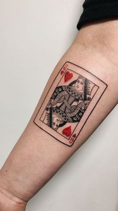 a tattoo on the arm of a person with a playing card in front of them