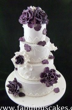 a three tiered wedding cake with purple flowers