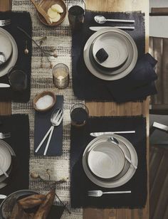 the table is set with dishes and utensils