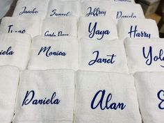 many towels with names on them sitting on a table