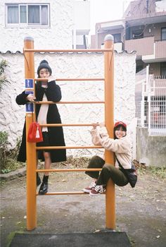 two children are playing on a wooden structure