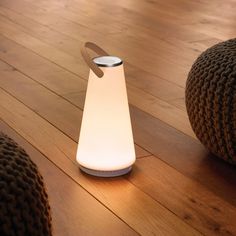 a white lamp sitting on top of a wooden floor