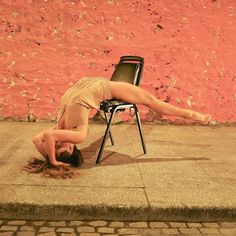 a woman laying on the ground in front of a chair with her legs spread out