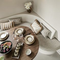 an overhead view of a table with plates and bowls on it, next to a bowl of fruit