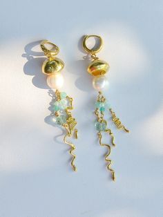 🌟 Make a statement with our unique handmade Jellyfish Earrings, designed to capture the beauty of nature. 🌟 🌊 Meticulously crafted by hand, these earrings feature high-quality brass and huggie hoop closures. Adorned with real pearls and natural fluorite stones, they add a touch of oceanic charm to any outfit. ✨ Measuring 9 cm in length and 1.3 cm in width, these earrings are perfectly sized to complement any face shape. ⚖️ Weighing 14.5 grams per pair, they are comfortable to wear all day lon Whimsical Brass Dangle Earrings, Whimsical Gold Wire Wrapped Earrings, Jelly Fish Earrings, Handmade Whimsical Brass Earrings, Nature-inspired Gold Wire Wrapped Earrings, Handmade Ocean-inspired Gold Earrings, Whimsical Gold Jewelry For Summer, Handmade Jellyfish, Jellyfish Earrings