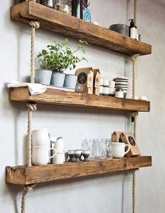 two wooden shelves with rope hanging from the sides and pots on top of each shelf