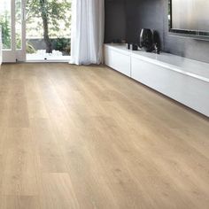 a living room filled with furniture and a flat screen tv on top of a wooden floor