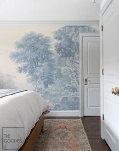 a bedroom with a bed, rug and wallpaper on the walls in front of it