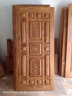 the wooden doors are made from wood and have intricate carvings on each door, along with other pieces of furniture