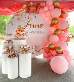 a birthday party with balloons, cake and cupcakes on the table in front of an amma sign