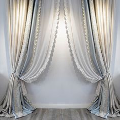 an empty room with white curtains and wooden floors