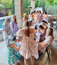 a group of women sitting around a table next to each other in front of a pool