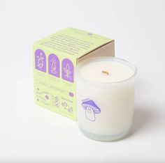 a white candle sitting in front of a box