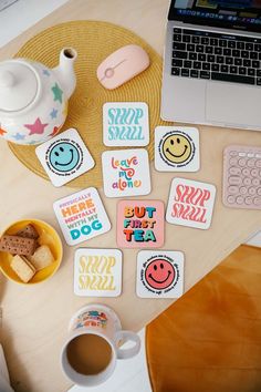 various coasters on a table next to a laptop and coffee cup with a teapot