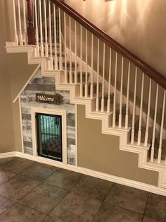 a dog house built into the side of a stair case with a fireplace in it