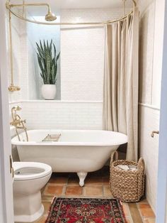 a white bath tub sitting next to a toilet in a bathroom