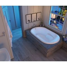 a bath tub sitting next to a window in a bathroom